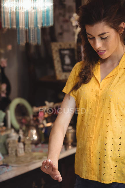 Woman looking at a vintage ring in antique shop — Stock Photo