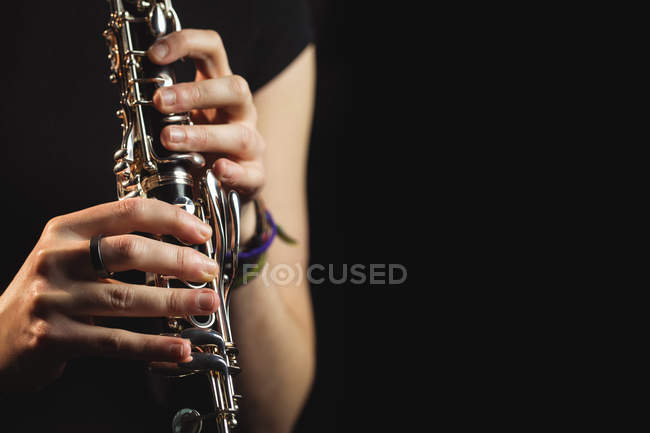 Sección media de la mujer tocando un clarinete en la escuela de música - foto de stock