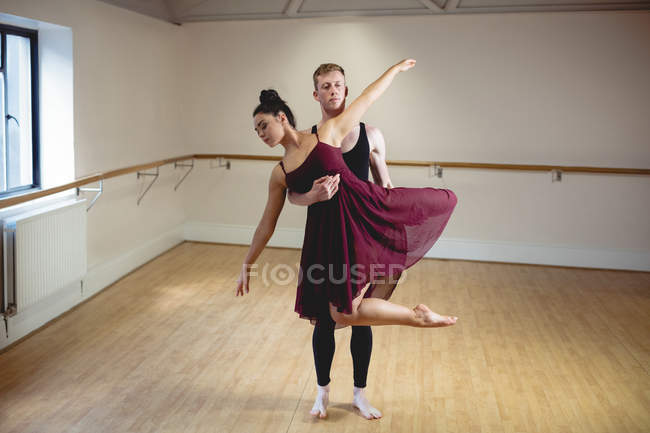 Молодые партнеры по балету танцуют вместе в современной студии — стоковое фото