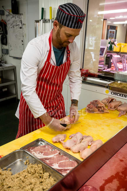 Açougueiro cortando frango no balcão de trabalho no açougue — Fotografia de Stock