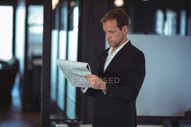Geschäftsmann liest Finanzbericht im Amt — Stockfoto