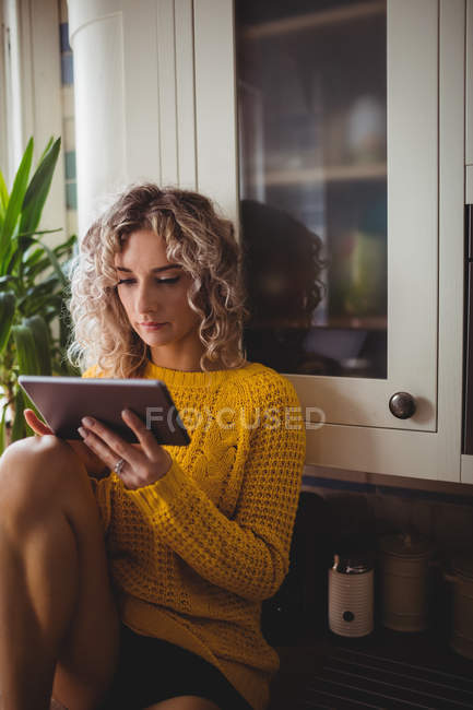 Bella donna che utilizza tablet digitale in cucina a casa — Foto stock