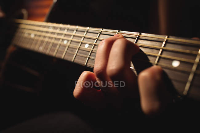Close-up of woman playing a guitar in music school — Stock Photo