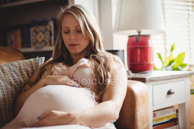 Foco seletivo da mulher grávida relaxando na sala de estar em casa — Fotografia de Stock
