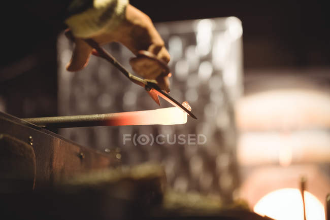 Soffiatore di vetro che lavora su vetro fuso alla fabbrica di soffiaggio del vetro — Foto stock