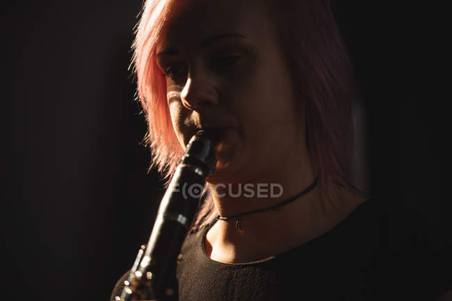 Primer plano de la mujer tocando un clarinete en la escuela de música - foto de stock