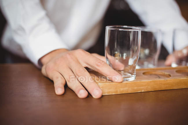 Barkeeper arrangiert Bierglas auf Tablett an Theke in Bar — Stockfoto
