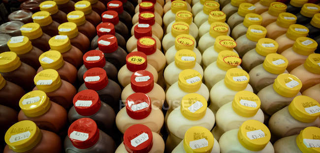 Gros plan de différentes bouteilles de sauce conservées dans un présentoir de magasin — Photo de stock