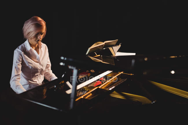 Female student playing piano in a studio — Stock Photo