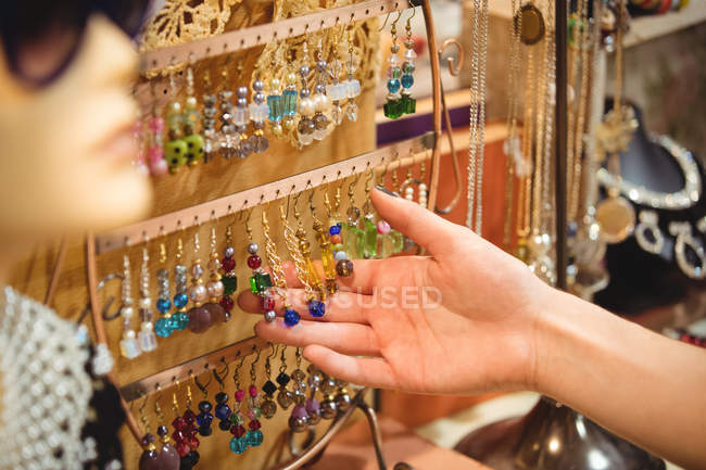 Hand of a woman holding vintage jewellery in antique shop — Stock Photo