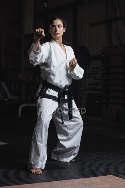 Mujer practicando karate en gimnasio - foto de stock