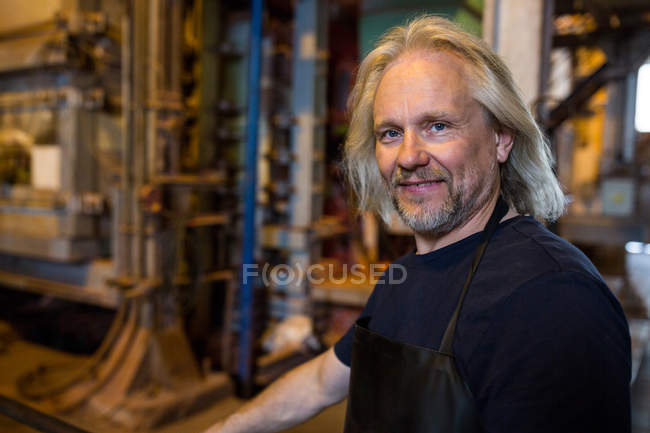Портрет улыбающегося стеклодува на стекольном заводе — стоковое фото