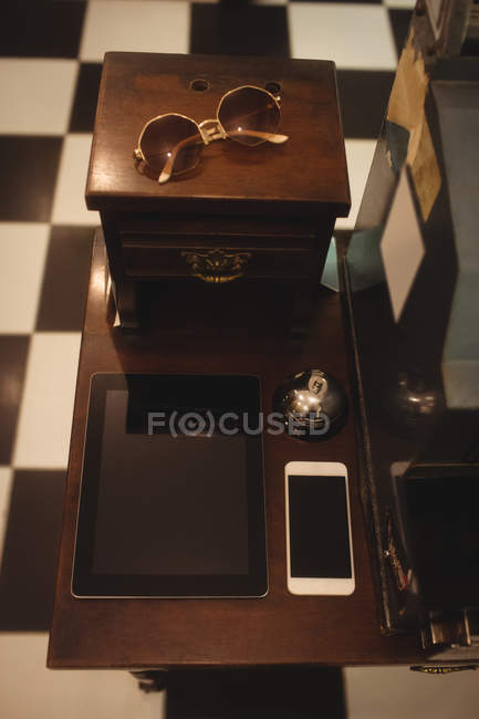 Tablet digital e smartphone mantidos na mesa antiquada — Fotografia de Stock
