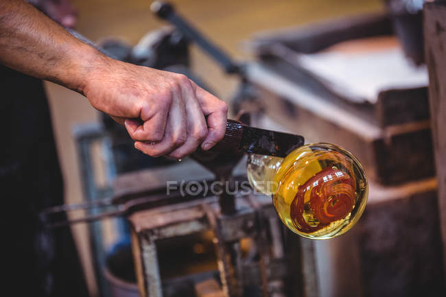 Main de souffleur de verre façonnant un verre fondu à l'usine de soufflage de verre — Photo de stock