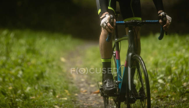 Athlete cycling on dirt track in forest — Stock Photo