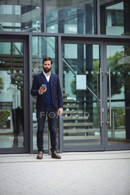 Бізнесмен, використовуючи мобільний телефон за межами офісу — стокове фото