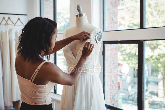 Modedesignerin justiert Kleid an Schaufensterpuppe im Atelier — Stockfoto