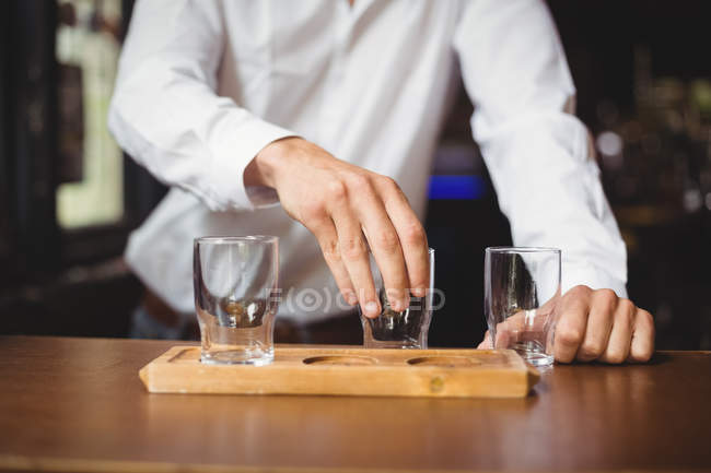 Barman arrangeant verre de bière sur plateau au comptoir du bar dans le bar — Photo de stock