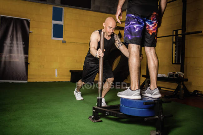 Thai boxers practicing weight exercise in fitness studio — Stock Photo