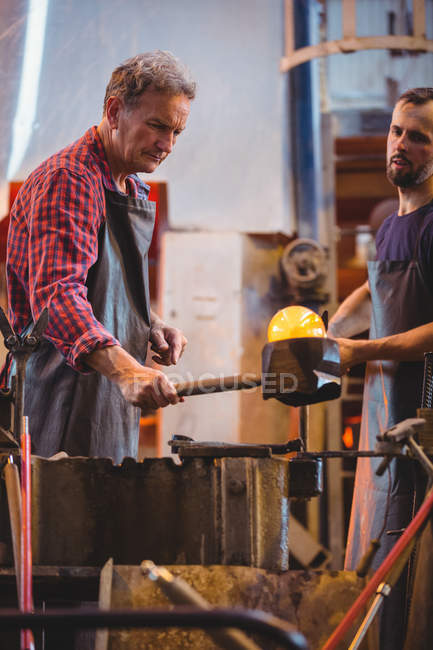 Glassblowers forming and shaping a molten glass at glassblowing factory — Stock Photo