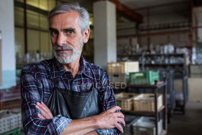 Портрет стеклодува со скрещенными руками на стекольном заводе — стоковое фото