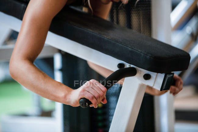 Mujer realizando ejercicio en press de banca en gimnasio - foto de stock