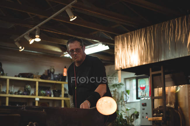Стеклодув формы расплавленного стекла на заводе стеклодувки — стоковое фото