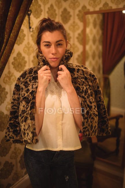 Portrait of a woman trying a fur jacket at boutique store — Stock Photo
