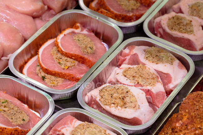 Close-up de carne marinada no balcão de exposição no talho — Fotografia de Stock