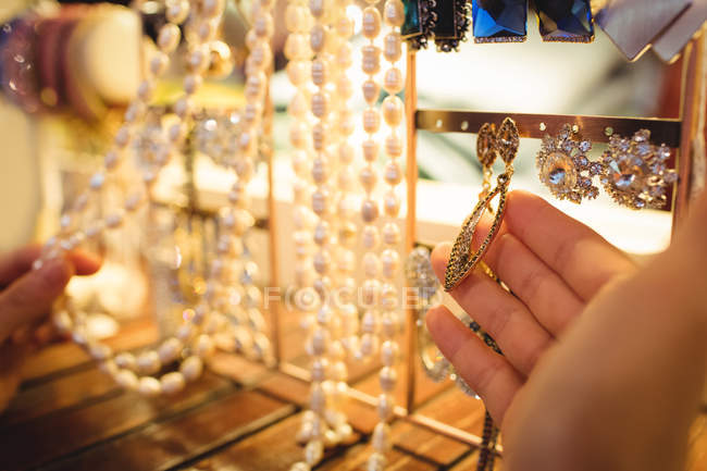 Hand of woman selecting jewellery in a antique jewellery shop — Stock Photo