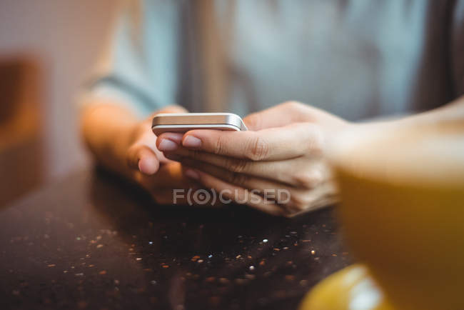 Messaggi di testo donna sul cellulare al caffè — Foto stock