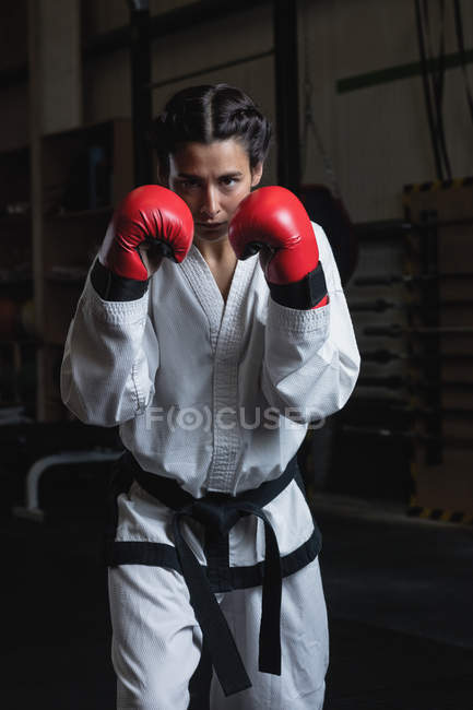 Портрет уверенной женщины в боксёрских перчатках в фитнес-студии — стоковое фото