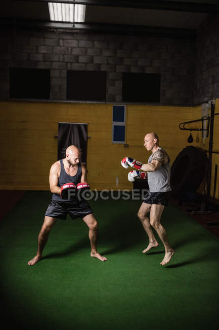 Vista lateral de dois boxers tailandeses praticando no ginásio — Fotografia de Stock