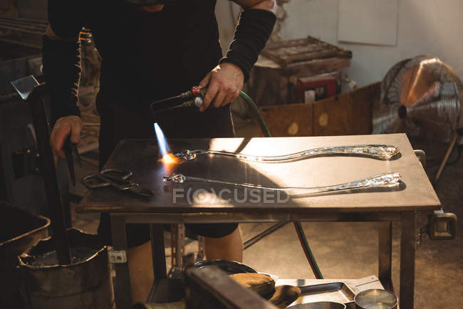 Imagen recortada de soplador de vidrio trabajando en vidrio fundido en fábrica de soplado de vidrio - foto de stock