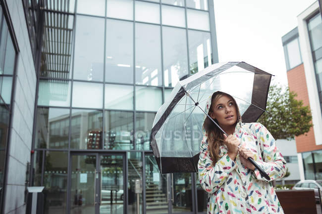 Mulher bonita segurando guarda-chuva durante a estação chuvosa — Fotografia de Stock