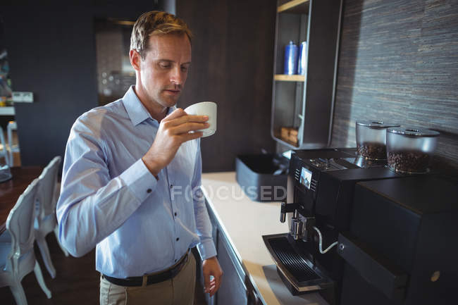 Businessman having coffee in office cafeteria — Stock Photo