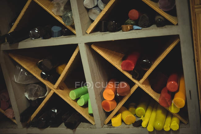 Varillas de vidrio dispuestas en el estante en la fábrica de soplado de vidrio - foto de stock