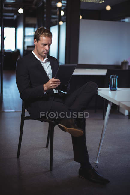 Hombre de negocios concentrado usando tableta digital en la oficina - foto de stock