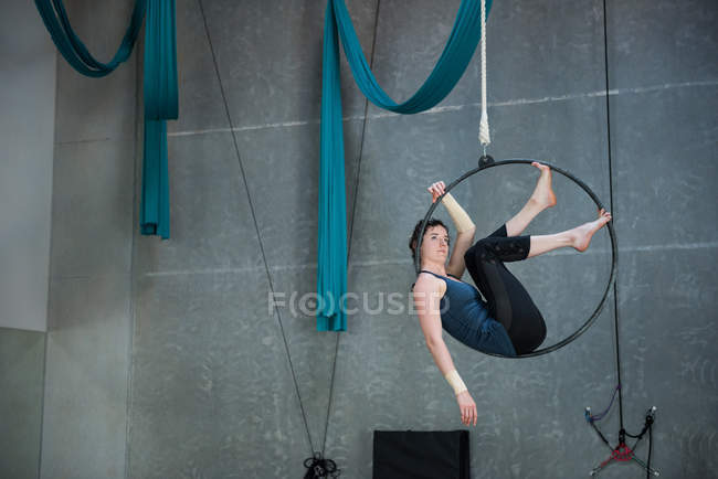 Gymnaste féminine faisant de la gymnastique sur cerceau dans un studio de fitness — Photo de stock