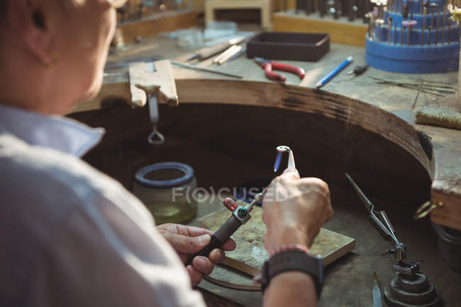 Gros plan de l'artisan à l'aide de chalumeau dans l'atelier — Photo de stock