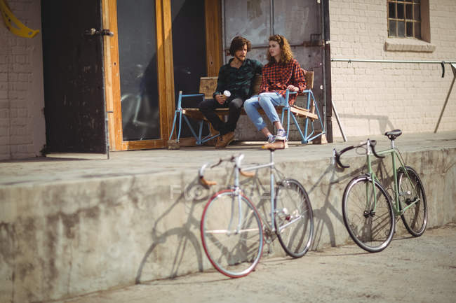 Couple sitting on chair and interacting outside the house — Stock Photo