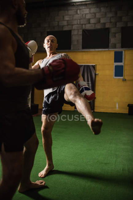 Foyer sélectif de deux boxeurs thai pratiquant la boxe dans la salle de gym — Photo de stock