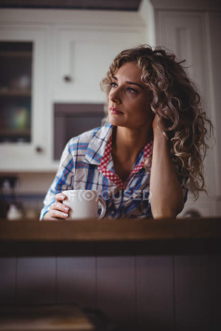 Nachdenkliche Frau beim Kaffee in der heimischen Küche — Stockfoto