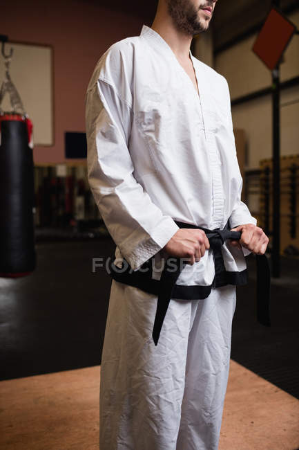Imagem cortada do homem em karatê quimono de pé no estúdio de fitness — Fotografia de Stock