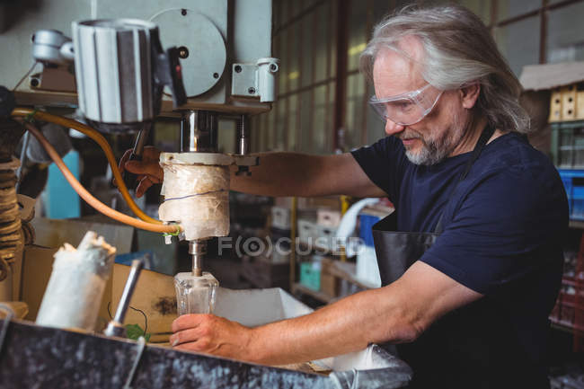Soffiatore di vetro che lavora su un vetro alla fabbrica di soffiaggio del vetro — Foto stock
