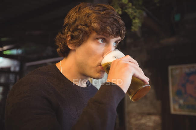 Mann trinkt ein Glas Bier an Bar — Stockfoto