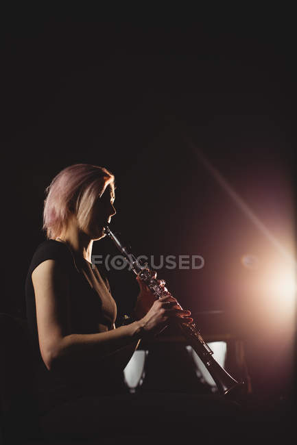 Женщина играет на кларнете в музыкальной школе — стоковое фото