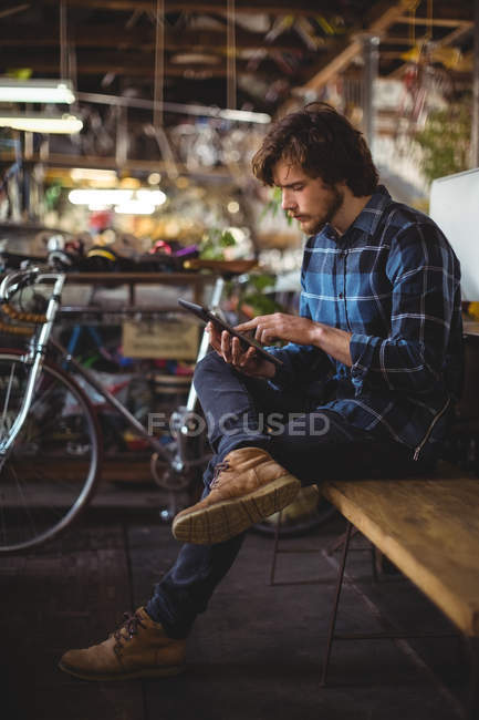 Человек с помощью цифрового планшета в мастерской — стоковое фото