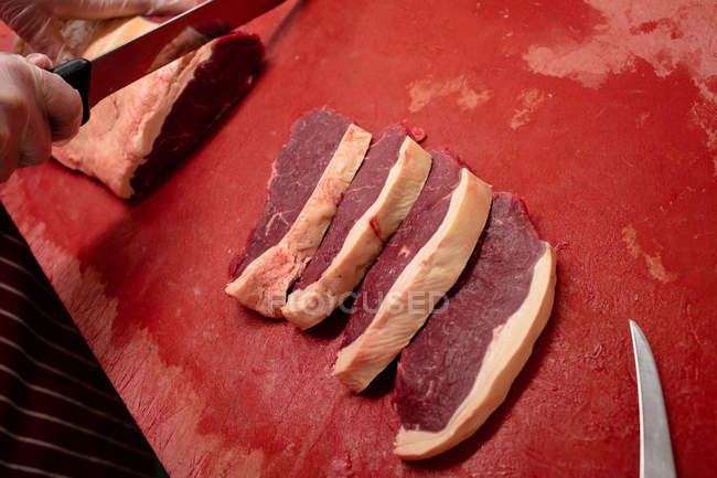Рука м'ясного нарізання м'яса в м'ясному магазині — стокове фото