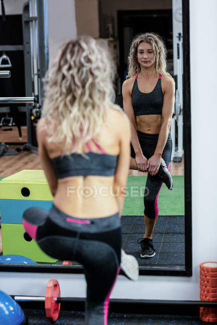 Belle femme faisant de l'exercice dans la salle de gym — Photo de stock